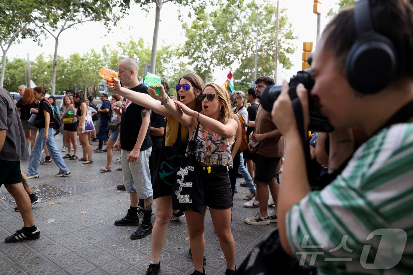 6일(현지시간) 스페인 바르셀로나에서 오버 투어리즘에 반대하는 시위가 벌어진 가운데 시위대가 관광객을 향해 물총을 쏘고 있다. 24.07.06 ⓒ 로이터=뉴스1 ⓒ News1 김예슬 기자
