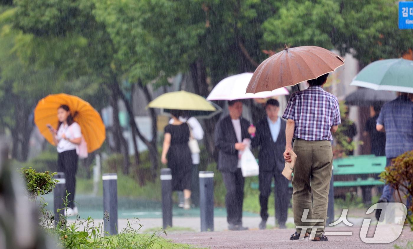 본문 이미지 - 광주와 전남에 장맛비가 예고된 8일 비가 내리자 광주시 서구 한 도로에 시민들이 우산을 쓰며 걸어가고있다. 2024.7.8/뉴스1 ⓒ News1 김태성 기자