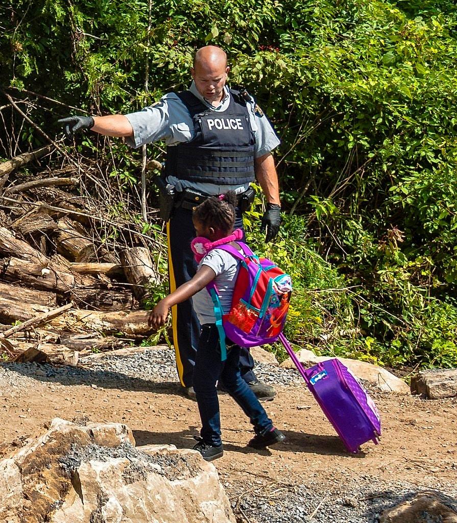 본문 이미지 - 난민 신청을 한 어린이가 Roxham Road 를 통해 캐나다로 건너가고 있다. 2024.07.07/ &lt;출처: 캐나다 백과사전&gt;