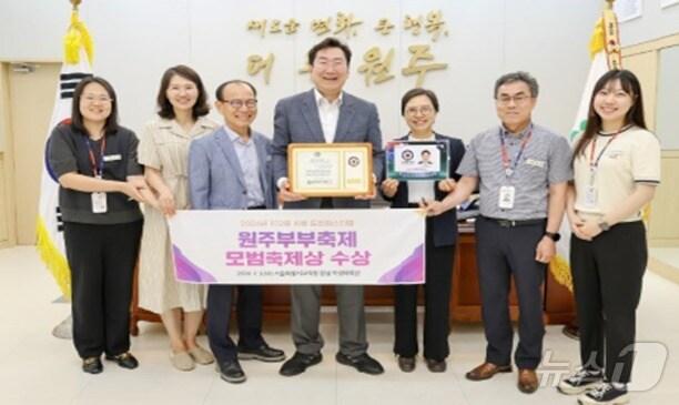 본문 이미지 - 강원 ‘원주 부부축제’가 7월3일 서울 잠실학생체육관에서 열린 ‘2024년 도전페스티벌’을 통해 전국 유일의 모범 우수축제로 선정된 가운데, 원강수 원주시장(가운데)과 시 관계자들이 최근 시청 시장 집무실에서 기념 사진을 촬영하고 있다. (원주시 제공) 2024.7.9/뉴스1