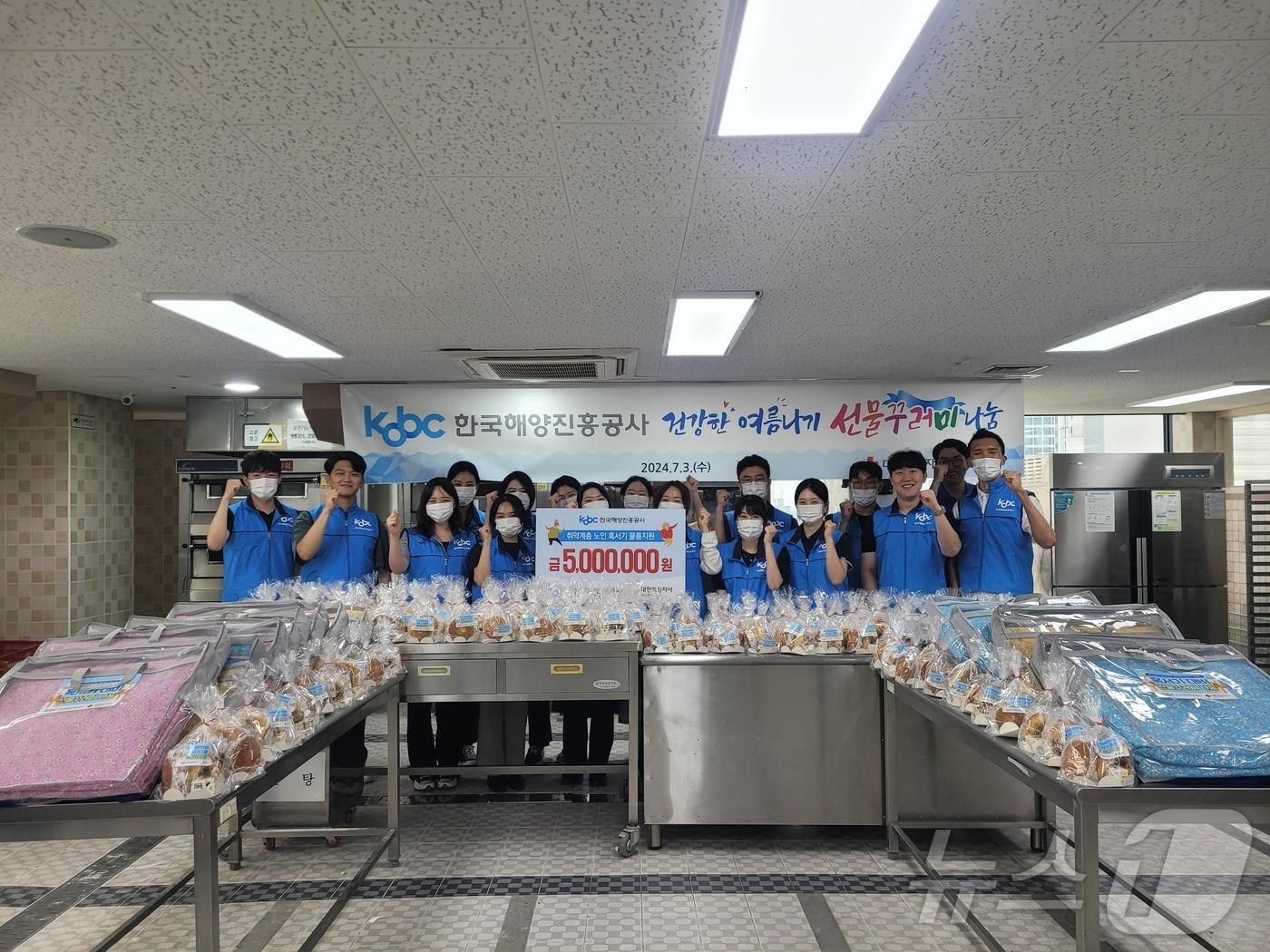 본문 이미지 - 해진공 임직원 20여 명이 지역 노인들에게 전달할 빵과 간식을 만들고 기념사진을 찍고 있다.(해진공 제공)