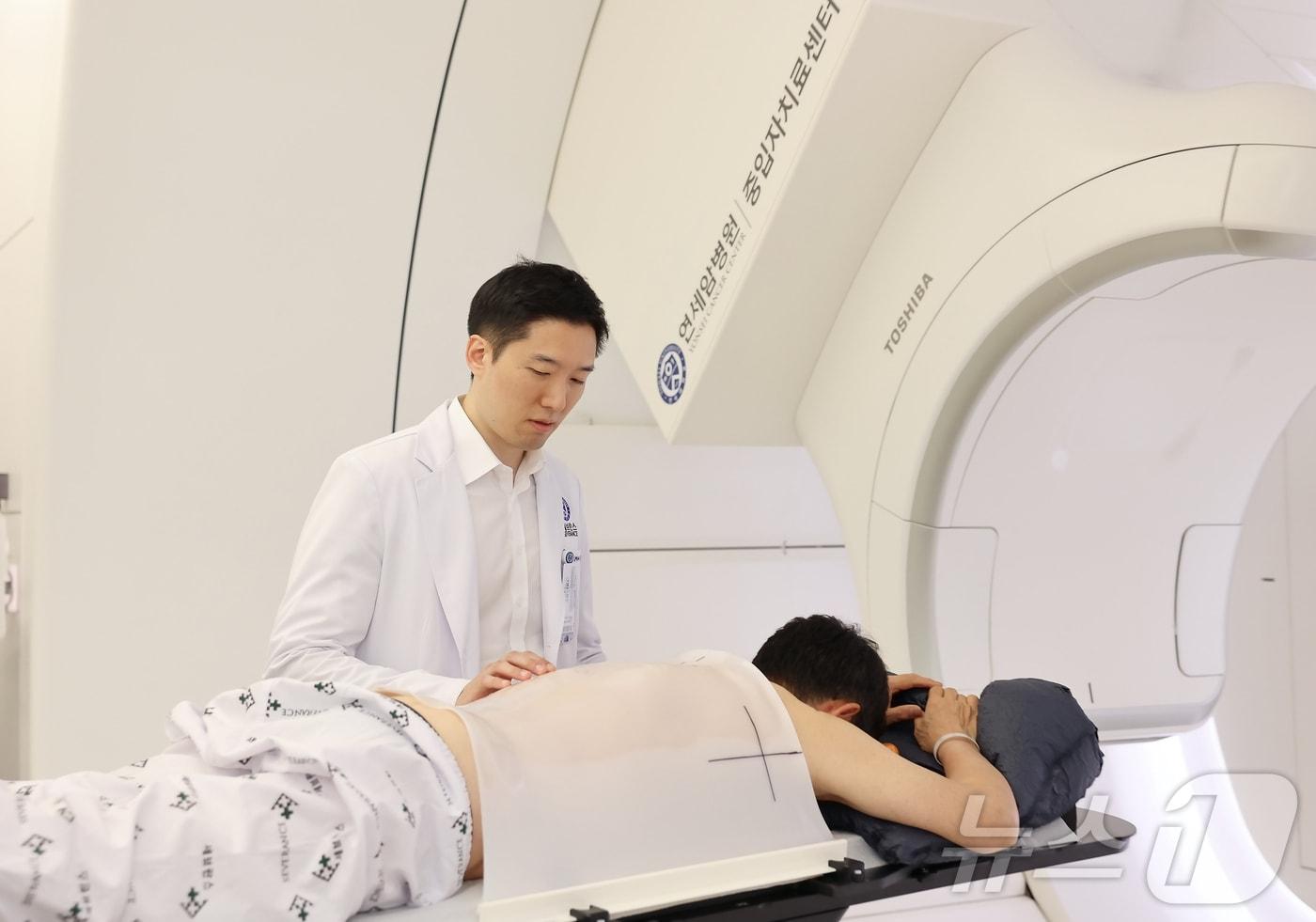 김경환 연세암병원 방사선종양학과 교수가 중입자치료 시작 전 환자를 살피고 있다. (병원 제공)
