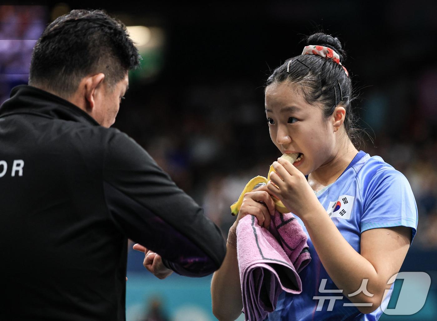 본문 이미지 - 대한민국 탁구 대표팀 신유빈 선수가 1일 오전(한국시간) 프랑스 파리 사우스 파리 아레나 4에서 열린 '2024 파리올림픽' 탁구 여자 단식 16강 미국의 릴리 장 선수와의 경기에서 체력 보충을 위해 바나나를 먹고 있다. 2024.8.1/뉴스1 ⓒ News1 박정호 기자