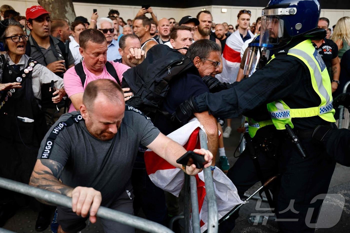 31일(현지시간) 영국 런던 다우닝 가 10번지 입구에서 시위대가 경찰에 저항하고 있다. 이날 시위는 지난 29일 영국 사우스포트에서 벌어진 흉기 난동에 대한 정부 반응 때문에 열렸다. 2024.07.31. ⓒ AFP=뉴스1 ⓒ News1 김종훈 기자