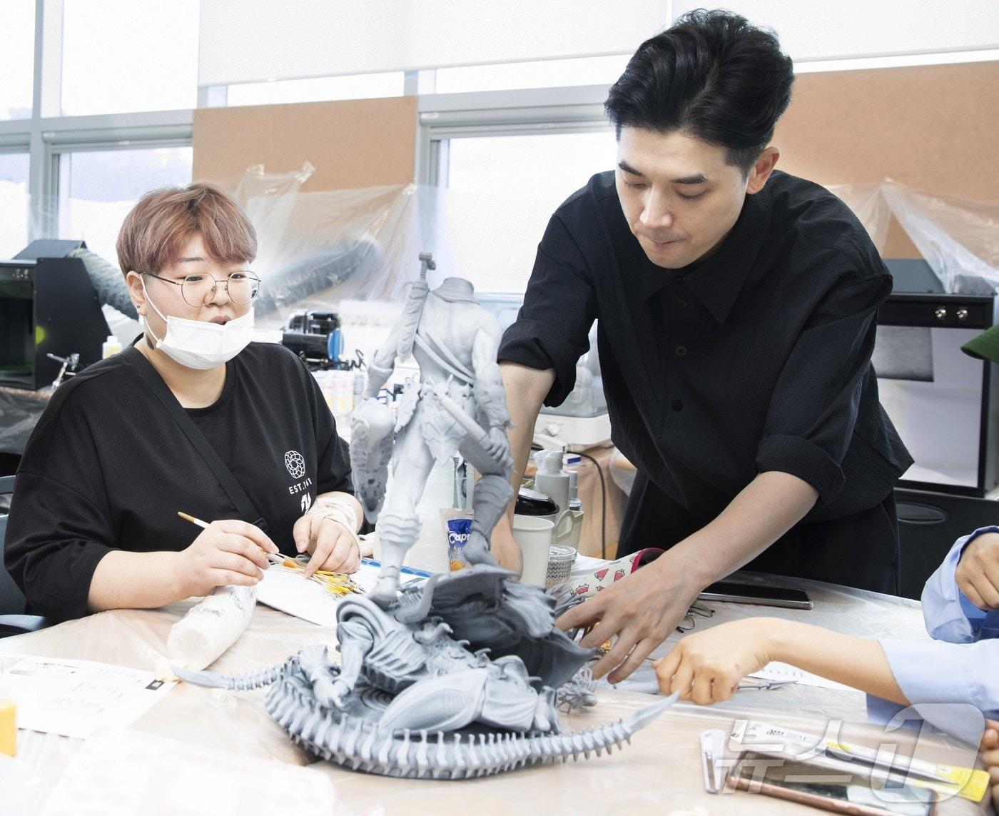 본문 이미지 - 권인선 배재대 아트앤웹툰학부 게임애니메이션전공 교수가 3D프린터로 출력된 캐릭터 프레데터 스태츄(Statue)를 보며 설명하고 있다. (배재대 제공)/뉴스1