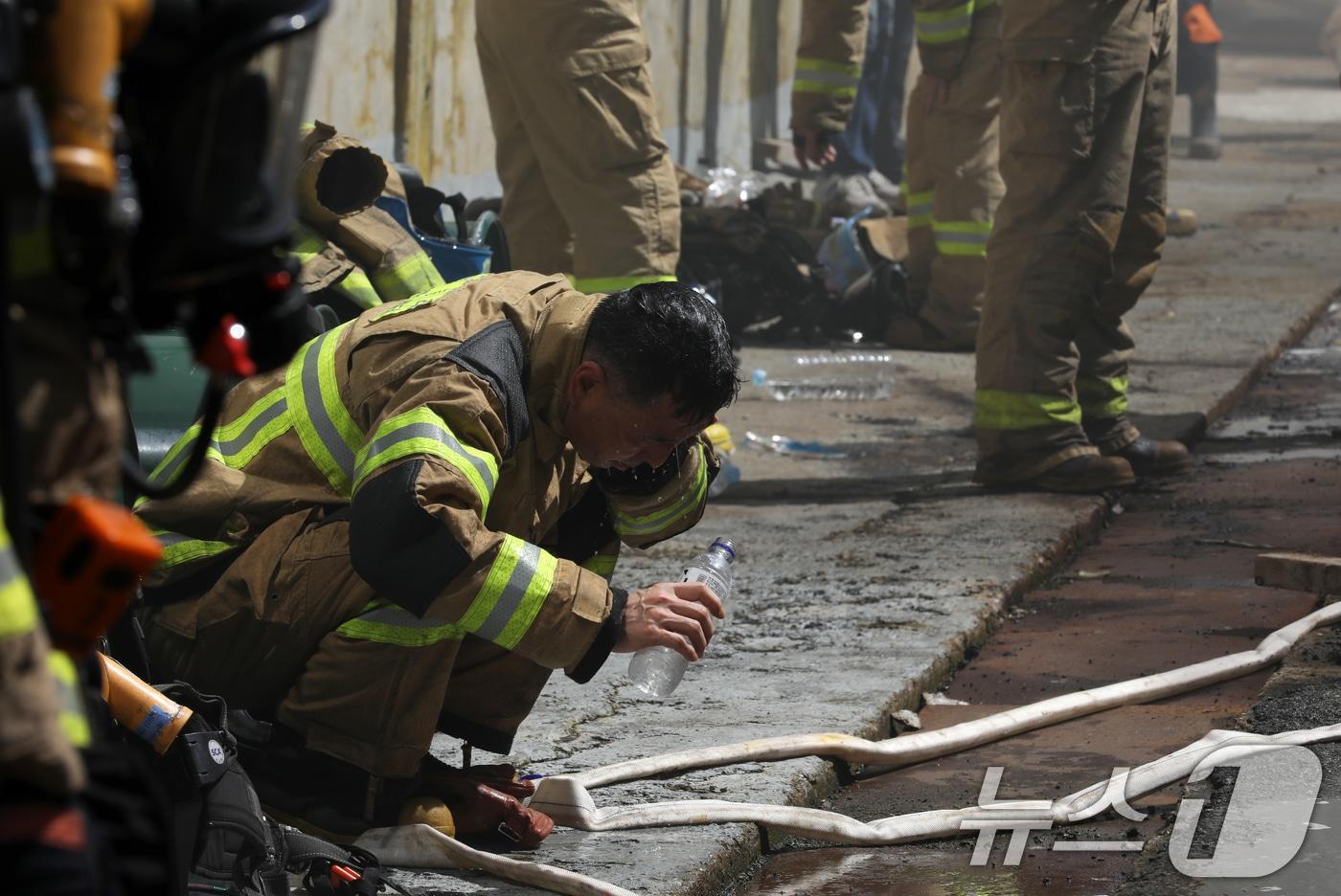 1일 오전 부산 금정구 회동동 한 화학물질 제조공장 2층 실험실에서 원인이 밝혀지지 않은 불이 난 가운데 진화작업에 나선 소방대원들이 잠깐 숨을 고르며 물로 더위를 식히고 있다. 소방당국은 대응 1단계를 발령하고 인원 98명과 장비를 동원해 화재 진화작업을 벌여 오전 7시 22분께 큰 불길을 잡았다. 2024.8.1/뉴스1 ⓒ News1 윤일지 기자