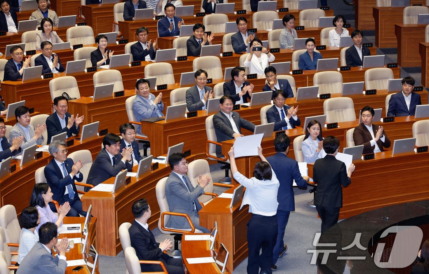 본문 이미지 - 정혜경(왼쪽부터), 윤종오, 전종덕 진보당 의원이 1일 오후 서울 여의도 국회에서 제416회국회(임시회) 제2차 본회의에 앞서 국민의힘 의원들을 향해 '대통령은 거부말라', '국민의힘은 동참하라'라고 적힌 손팻말을 들고 구호를 외친 뒤 자리로 향하며 야당 의원들로부터 박수받고 있다. 2024.8.1/뉴스1 ⓒ News1 안은나 기자