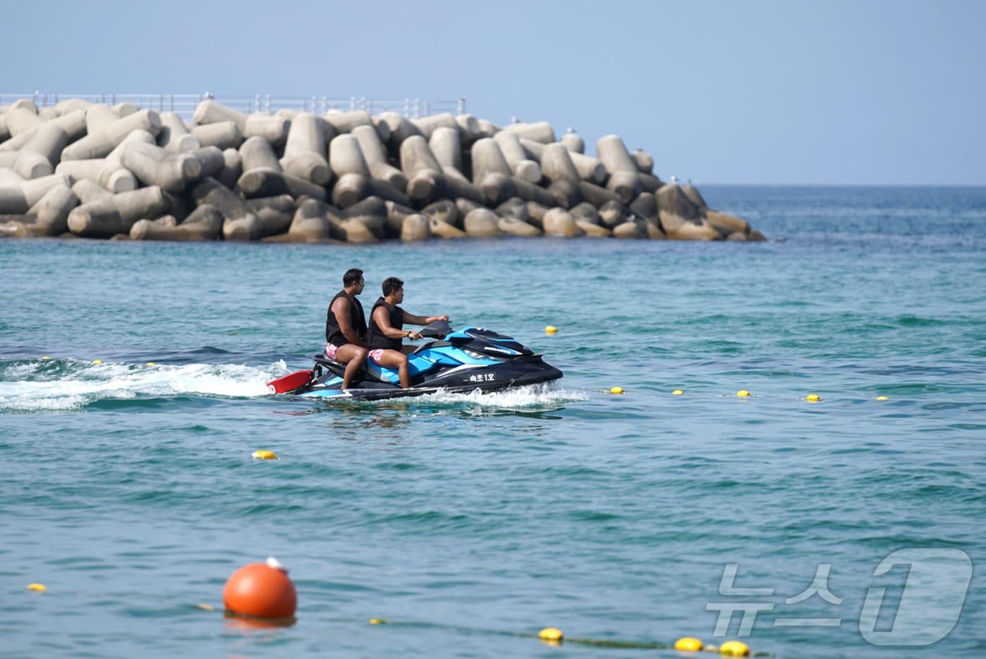 속초해수욕장에 설치된 해파리·상어 방지 그물망 뒤로 수상안전요원들이 해파리 채집을 위해 순찰 중이다.(속초시 제공) 2024.8.1/뉴스1