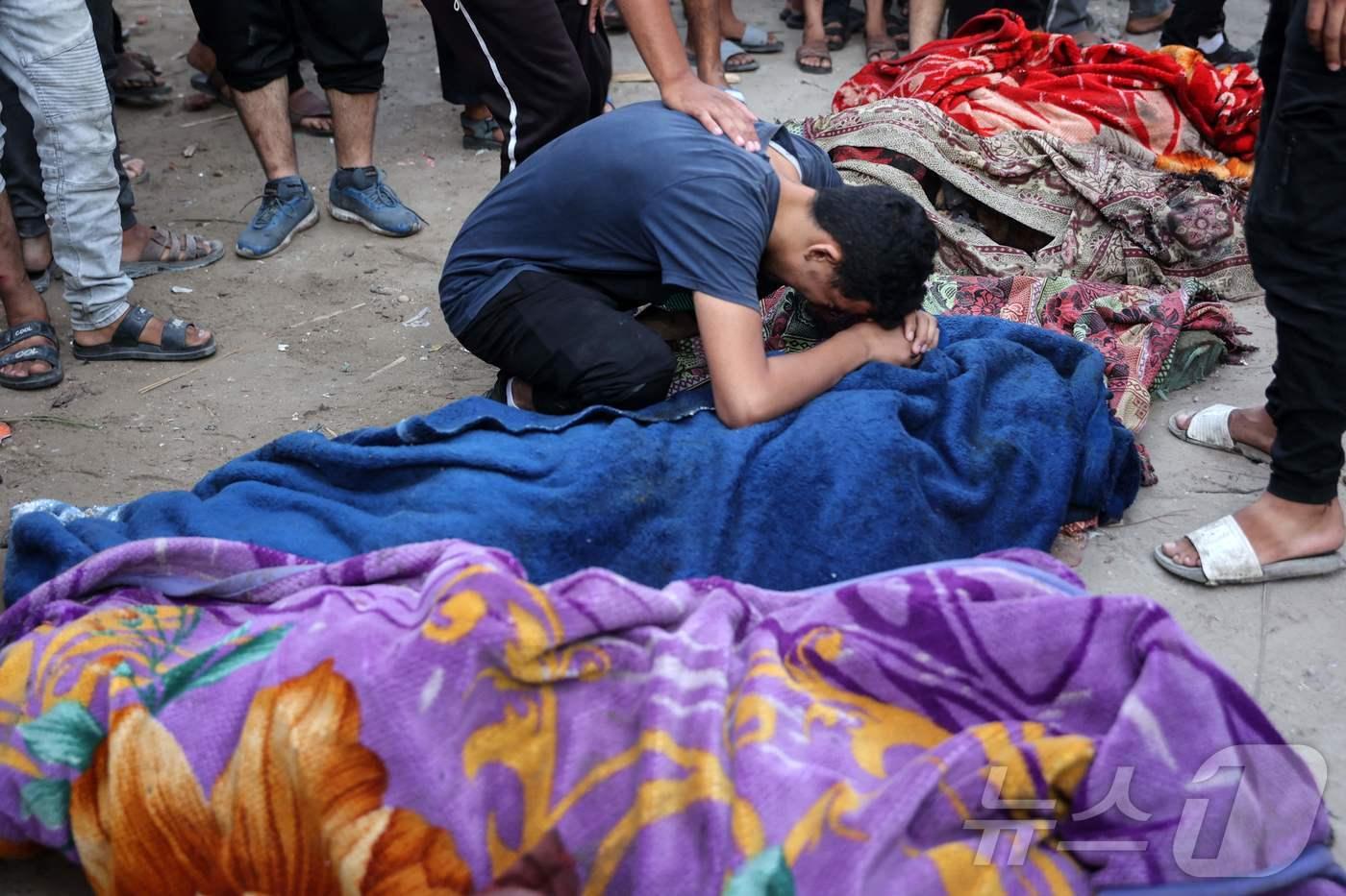 10일(현지시간) 가자지구 가자시티에서 한 청년이 이스라엘군의 공격으로 사망한 희생자의 시신 곁에서 오열하고 있다. 이날 이스라엘군은 피난민들이 머물고 있던 학교를 공격했다. 2024.08.10/ ⓒ AFP=뉴스1 ⓒ News1 권진영 기자