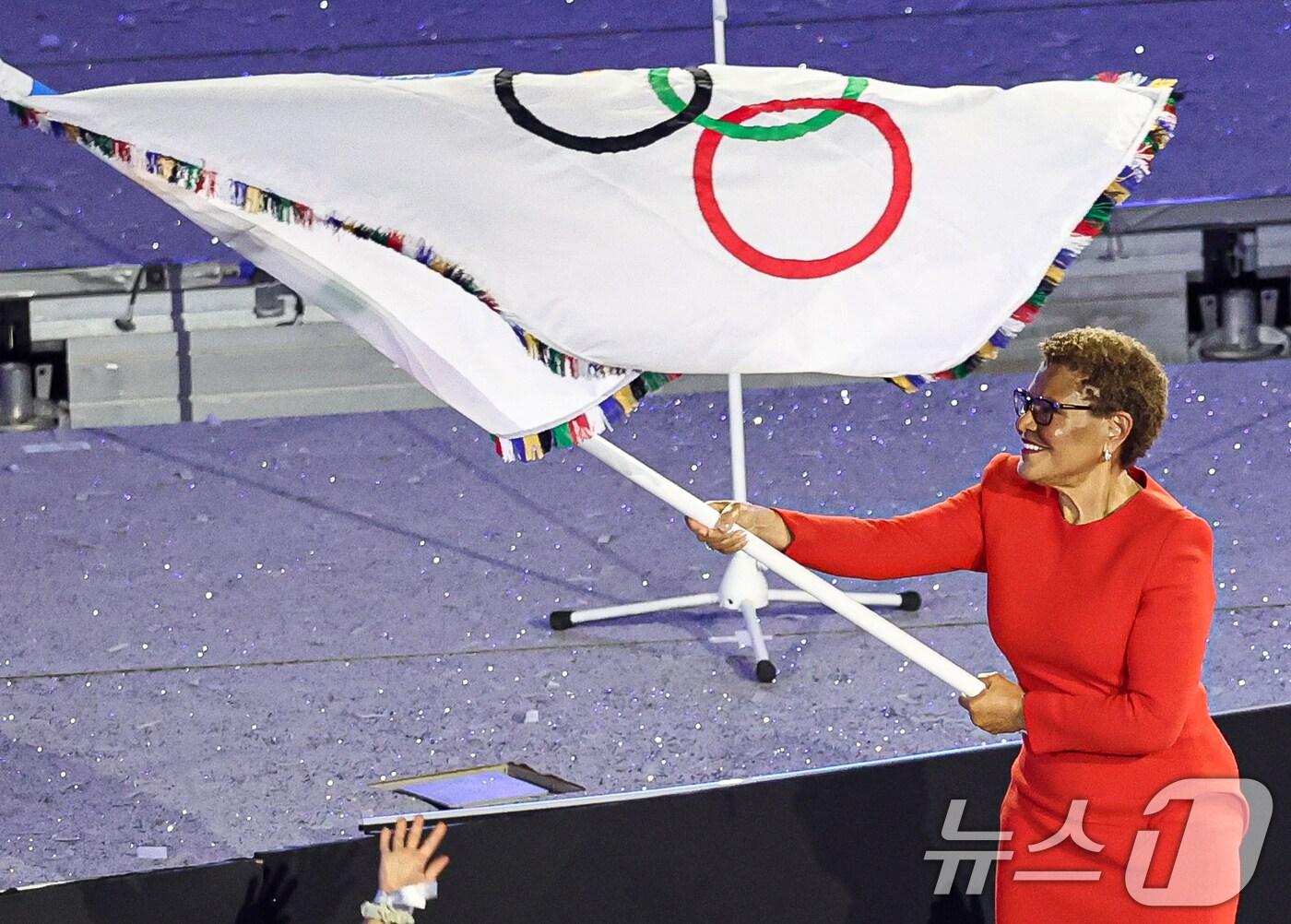 본문 이미지 - 캐런 배스 로스엔젤레스 시장이 12일(한국시간) 프랑스 파리 스타드 드 프랑스에서 열린 2024 파리올림픽 폐막식에서 대회기를 흔들고 있다. (공동취재) 2024.8.12/뉴스1 ⓒ News1 이동해 기자
