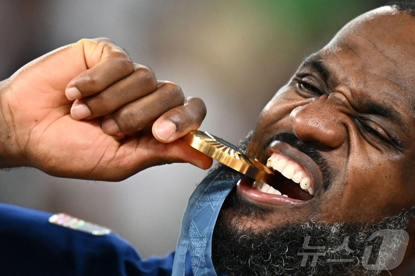 미국 농구 대표팀의 르브론 제임스가 10일(현지시간) 파리의 베르시 아레나에서 열린 파리 올림픽 남자 농구 결승전서 프랑스를 꺾고 5연속 우승을 한 뒤 금메달을 깨물고 있다. 2024.08.12 ⓒ AFP=뉴스1 ⓒ News1 우동명 기자