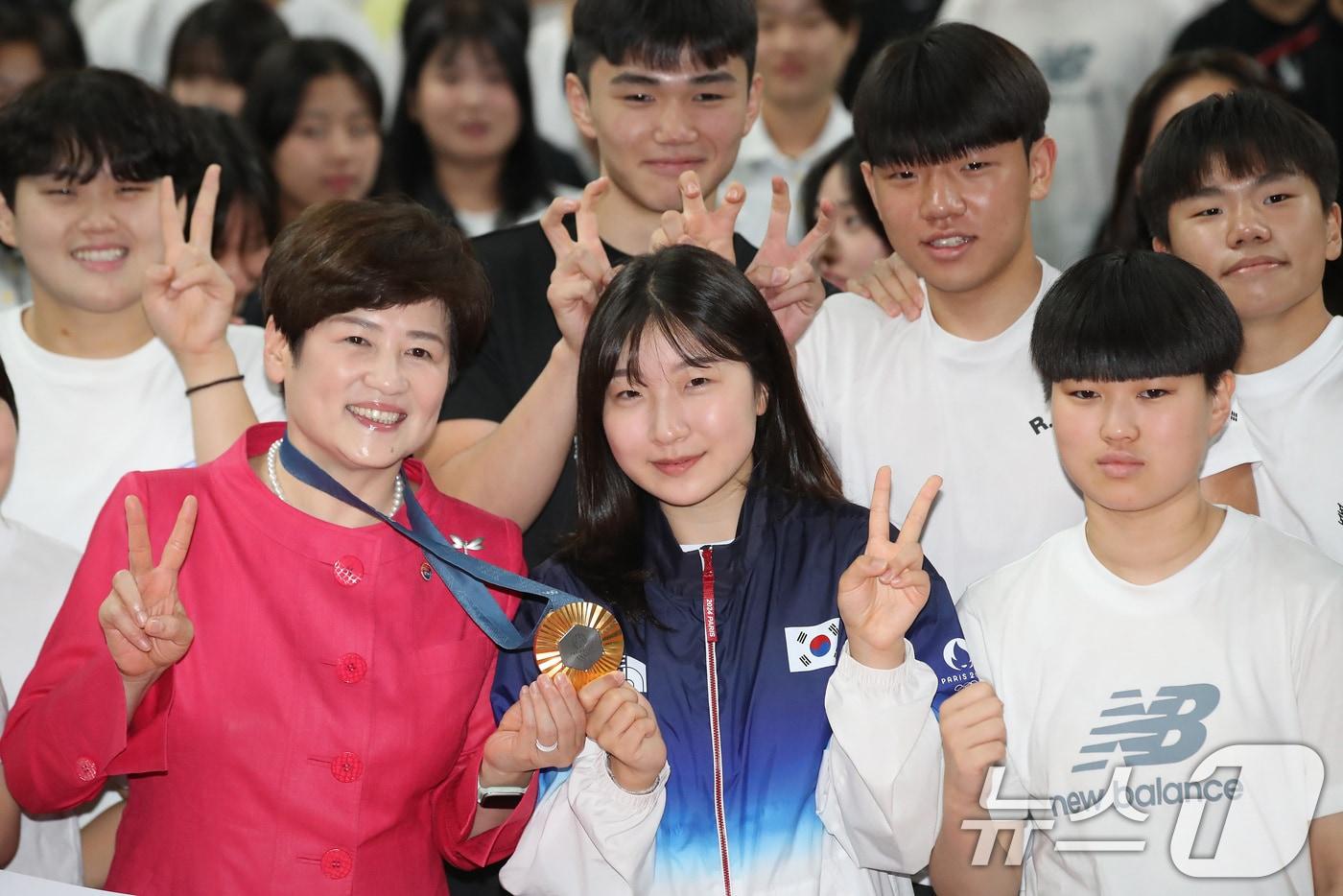 본문 이미지 - 2024 파리올림픽 사격 여자 10m 공기소총 금메달리스트 반효진(가운데)이 12일 오전 대구 북구 대구체고에서 열린 환영식에 참석해 강은희 교육감(왼쪽)과 사격부 친구 전보빈(오른쪽)을 비롯한 친구들과 기념촬영을 하고 있다. 2024.8.12 ⓒ 뉴스1 공정식 기자