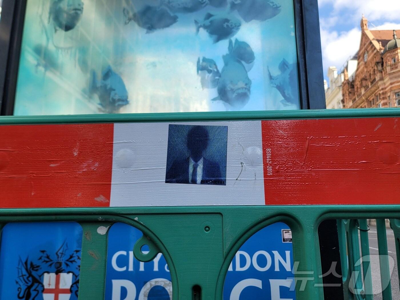 본문 이미지 - 영국의 &#39;얼굴 없는 거리 예술가&#39; 뱅크시의 일곱 번째 동물 시리즈 작품이 11일&#40;현지시각&#41; 오후 런던 루드게이트힐에 있는 한 경찰 박스&#40;police box&#41; 외관에 피라냐 떼가 그려진 모습으로 공개됐다. 런던시가 경찰 박스 주위로 바리케이드를 설치해 놓은 모습.  2024.08.11/ ⓒ 뉴스1 조아현 통신원