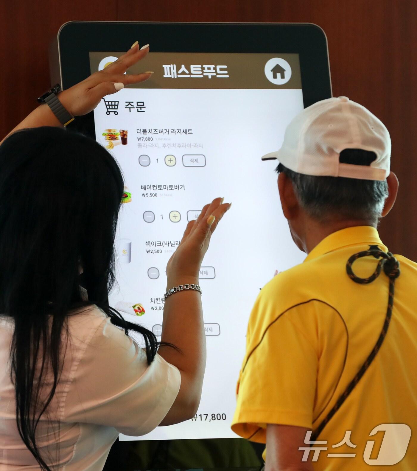 본문 이미지 - 13일 오후 부산 부산진구 롯데호텔에서 국가를 위한 헌신에 대한 감사와 예우의 의미를 담은 '영웅의 날'(히어로즈 데이) 행사가 열린 가운데 보훈대상자 어르신이 키오스크 사용법을 배우고 있다. 국가보훈부는 이날 제79주년 광복절을 앞두고 KT와 함께 부산지역 독립유공자 후손을 비롯한 참전유공자 및 배우자 50여 명을 초청해 오찬과 고령자 맞춤형 프로그램을 통해 '특별한 하루'를 선물했다. 2024.8.13/뉴스1 ⓒ News1 윤일지 기자