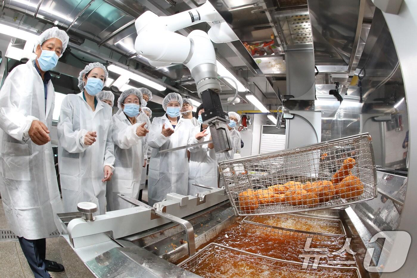 본문 이미지 - 8월13일 대구 동구 팔공초·중학교 조리실에서 열린 '학교급식형 튀김로봇 시연회'를 찾은 강은희 교육감과 교육청 관계자, 학부모 대표 등이 튀김 과정을 지켜보고 있다. (사진은 기사 내용과 무관함) 2024.8.13/뉴스1 ⓒ News1 공정식 기자