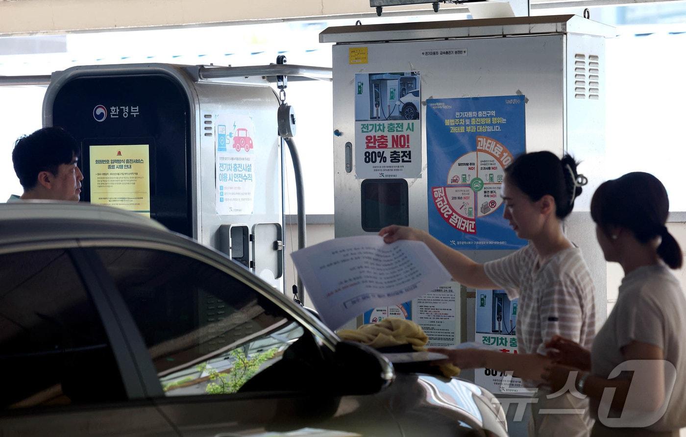 광주 북구청  직원들이 전기차의 충전상태와 충전시설 이용시 안전수칙 홍보물을 부착하고 있다.(광주 북구 제공. 재판매 및 DB 금지)/뉴스1 