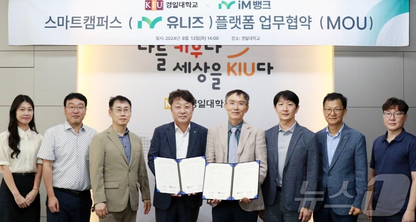 본문 이미지 - 김기만 iM뱅크 부행장&#40;왼쪽 네번째&#41;과 홍재표 경일대 경영부총장&#40;오른쪽 네번째&#41;이 스마트캠퍼스 플랫폼 &#39;아이엠 유니즈&#40;iM uniz&#41;&#39; 구축을 위한 업무협약을 체결한 뒤 협약서를 펼쳐 보이고 있다.&#40;iM뱅크 제공&#41;