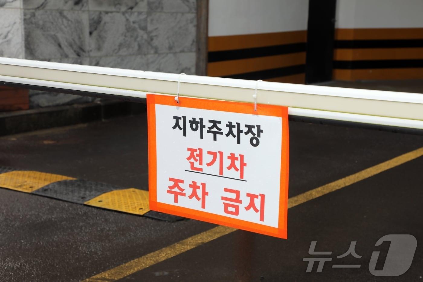 본문 이미지 - 14일 제주시내 한 지하주차장 입구에 전기차 주차를 금지한다는 안내문이 붙어있다. 지하주차장 내부에는 전기차 주차구역 표시가 있지만 기존에 설치됐던 충전기는 철거된 상태다. 2024.8.14/뉴스1 ⓒ News1 홍수영 기자