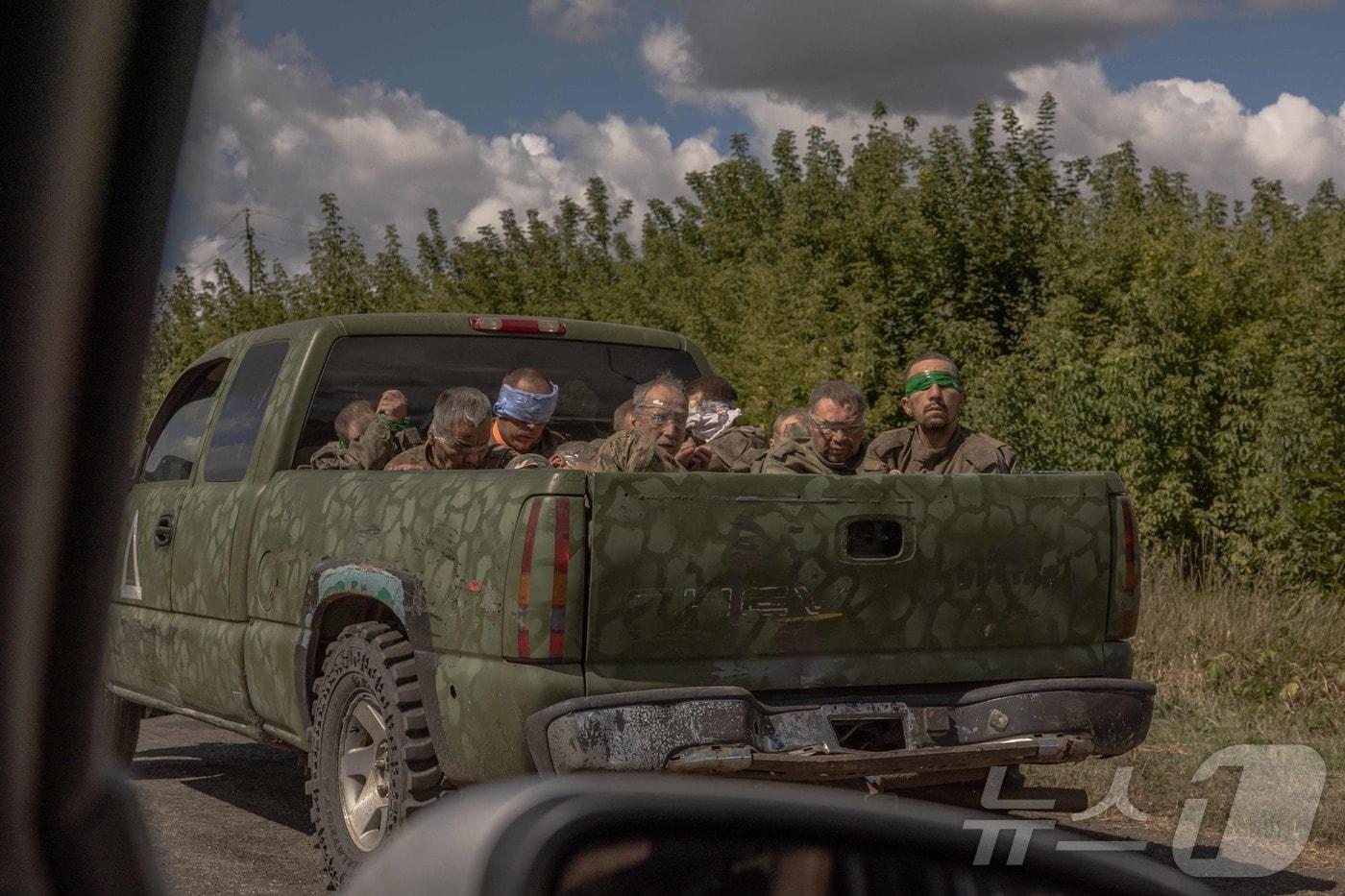 13일(현지시간) 우크라이나 수미 지역에서 우크라이나 군용 차량이 눈을 가린 러시아 군복 차림의 남성들을 태우고 어디론가 이동하고 있다. 2024.08.13 ⓒ AFP=뉴스1 ⓒ News1 김지완 기자