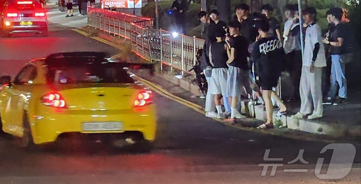 본문 이미지 - 15일 오전 1시께 충남 천안시 동남구 일봉산 사거리 일원에 모인 10대들이 굉음을 내며 운행하는 차량에 환호를 보내고 있다. 2024.8.15./뉴스1ⓒNews1 이시우 기자