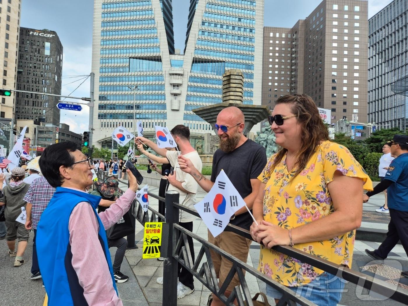 본문 이미지 - 광복절인 15일 태극기를 들고 있는 외국인 관광객들 모습 2024.8.15/뉴스1 ⓒ News1 조유리 기자