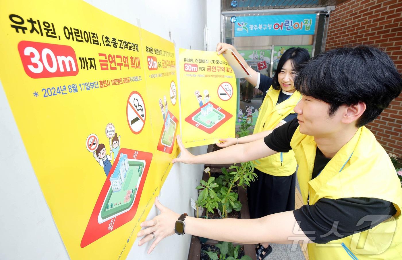 유치원과 어린이집, (초·중·고) 학교경계 30m까지 금역구역 확대 시행 하루 전인 지난해 8월 16일 광주 북구보건소 건강증진과 금연담당 직원들이 관내 한 어린이집 앞에 홍보 포스터를 부착하고 있다.(광주 북구 제공)/뉴스1 ⓒ News1 박지현 기자