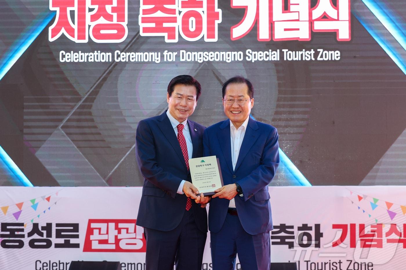 홍준표 대구시장(오른쪽)이 지난 16일 대구 동성로 28아트스퀘어에서 류규하 중구청장에서 동성로 관광특구 지정패를 전달하고 있다. (대구 중구 제공) 2024.8.16/뉴스1