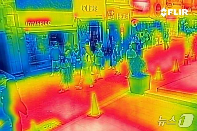 본문 이미지 - 무더운 날씨가 이어지고 있는 18일 오후 서울 명동거리에 냉방 중인 상점과 실외의 기온이 차이를 보이고 있다. 열화상 카메라는 온도가 높을수록 붉은색으로 나타나며 상대적으로 온도가 낮은 곳은 푸른색으로 나타난다. (열화상 카메라 촬영) 2024.8.18/뉴스1 ⓒ News1 신웅수 기자