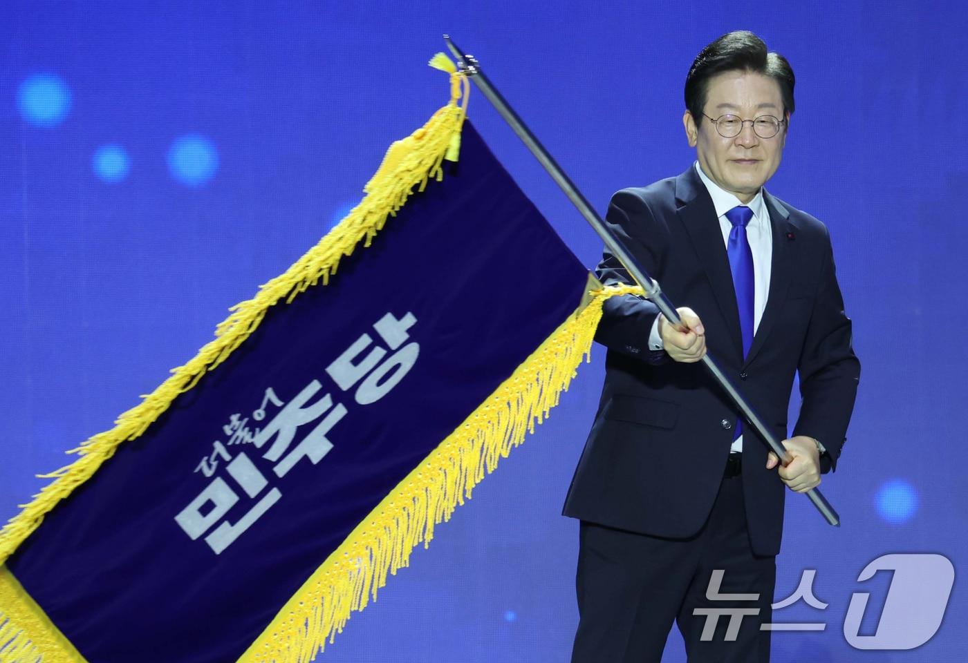 연임에 성공한 이재명 더불어민주당 대표가 18일 서울 송파구 올림픽공원 KSPO돔에서 열린 제1차 전국당원대회에서 당기를 흔들고 있다. (공동취재2024.8.18/뉴스1 ⓒ News1 김민지 기자
