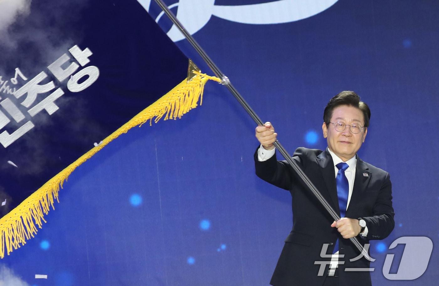 본문 이미지 - 더불어민주당 당대표 연임에 성공한 이재명 대표가 18일 오후 서울 송파구 올림픽공원 KSPO돔에서 열린 전국당원대회에서 당기를 흔들고 있다.(공동취재)2024.8.18/뉴스1 ⓒ News1 김민지 기자