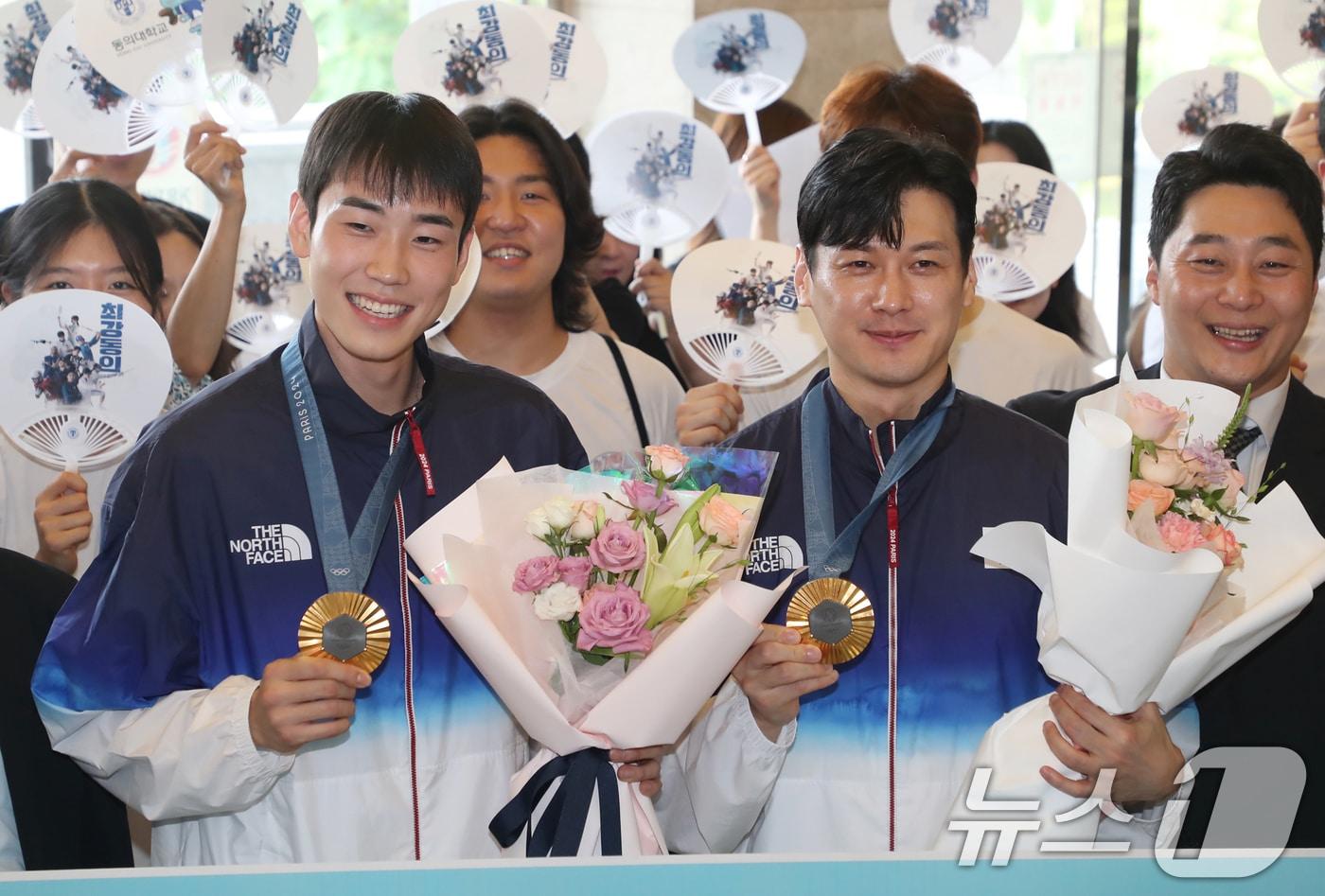 본문 이미지 - 2024 파리올림픽 펜싱 남자 사브르 단체전 금메달리스트 구본길, 도경동이 19일 오후 부산 동의대학교 대학본관에서 열린 환영식에서 펜싱부 후배, 학생, 교직원 등 참석자들과 기념촬영을 하고 있다. 2024.8.19/뉴스1 ⓒ News1 윤일지 기자