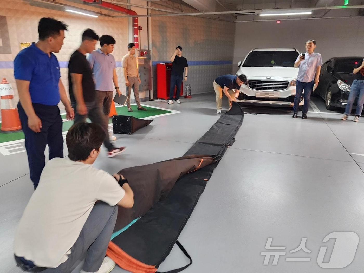 본문 이미지 - 질식소화 덮개 사용법 시연 모습. (용산구 제공)