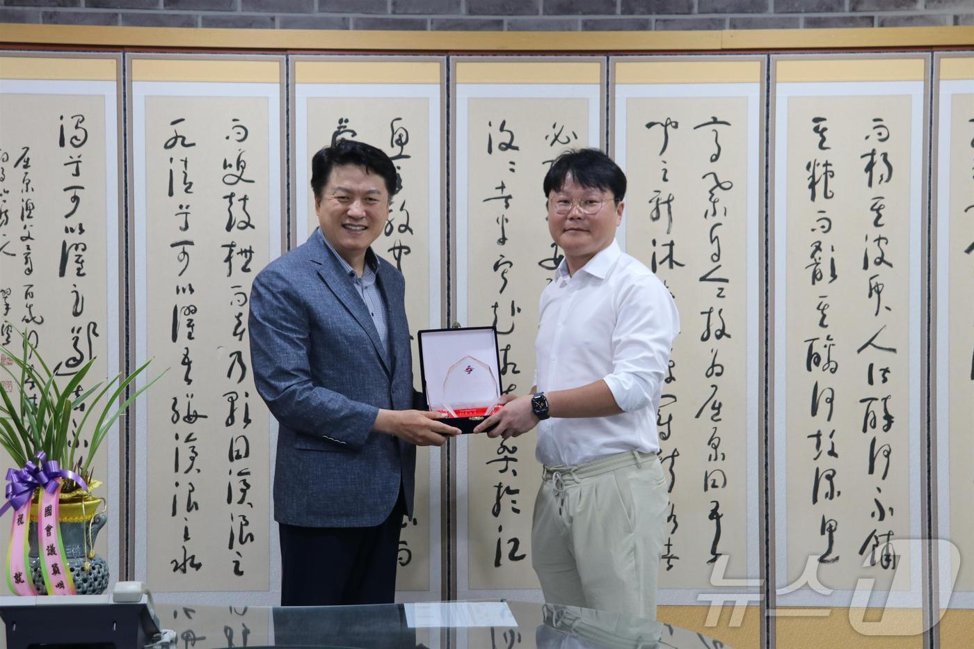 윤성찬 대한한의사협회장(왼쪽)이 장세인 대한스포츠한의학회장에게 공로패를 수여하고 있다.