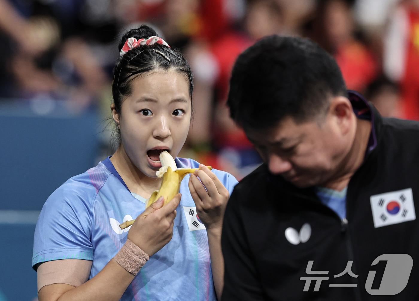 본문 이미지 - 대한민국 탁구 대표팀 신유빈 선수가 2일 오후(한국시간) 프랑스 파리 사우스 파리 아레나 4에서 열린 '2024 파리올림픽' 탁구 여자 단식 준결승 중국 첸멍 선수와의 경기에 앞서 바나나를 먹고 있다. 2024.8.2/뉴스1 ⓒ News1 이동해 기자