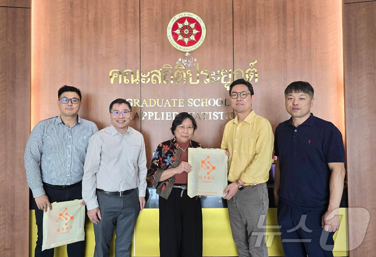 본문 이미지 - NIDA 행정부 응용통계대학원의 시기가 두사데노아드(Siwiga Dusadenoad) 학장(가운데)이 인제대 스마트물류학과 김민재 교수에게 기념품을 전달하고 있다.(인제대 제공)