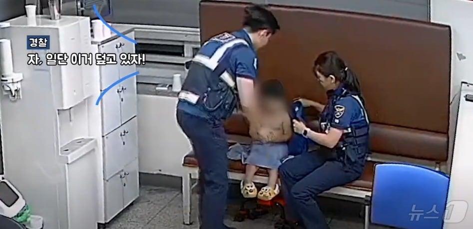 본문 이미지 - 지난달 21일 대전의 한 지구대에서 경찰관들이 길을 잃은 아동에게 수건을 덮어주고 있다. (대전경찰청 유튜브 갈무리)/뉴스1  