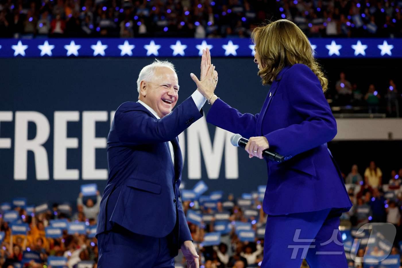 미국 민주당 대선 후보인 카멀라 해리스 부통령이  20일(현지시간) 위스콘신주 밀워키에서 열린 선거 집회 중 부통령 후보인 팀 월즈 미네소타 주지사와 하이 파이브를 하고 있다. 2024.08.21 ⓒ AFP=뉴스1 ⓒ News1 우동명 기자