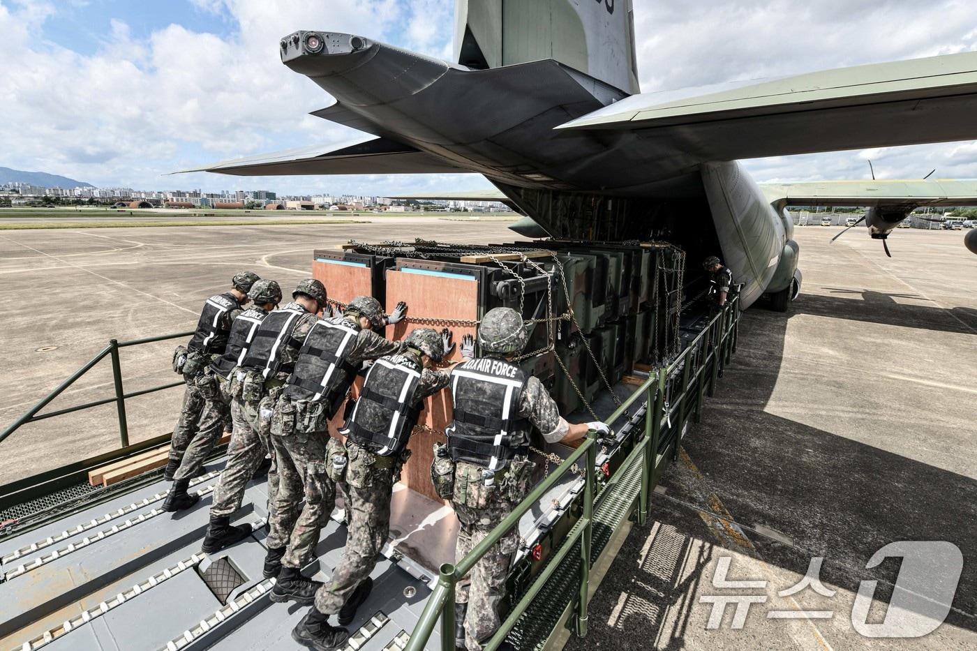 공군 군수사령부 예하 제601종합수송지원대대 장병들이 22일 대구기지 활주로에서 열린 천궁 유도탄 공중수송절차 숙달 훈련에서 카고로더(Cargo Loader)를 이용해 패트리어트·천궁 모의탄이 실린 화물운반대를 C-130J 수송기에 적재하고 있다. (공군 제공) 2024.8.22/뉴스1