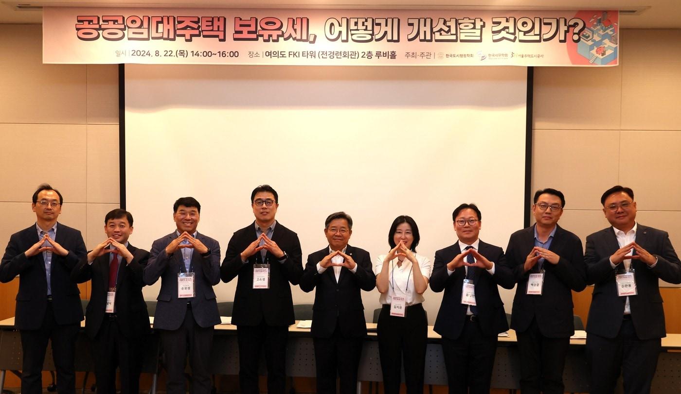 남원석 서울연구원 선임연구위원(왼쪽부터), 조남식 SH공사 자산관리처장, 손오성 SH도시연구원장, 고윤성 한국외국어대학교 교수, 김헌동 SH공사 사장, 김지은 SH도시연구원 수석연구원, 윤상만 서울과학기술대학교 교수, 백경엽 국회 예산정책처 세제분석2과장, 김완용 한양사이버대학교 교수 등 정책 토론회 참가자들이 손으로 집을 만들어 보이고 있다(SH공사 제공).