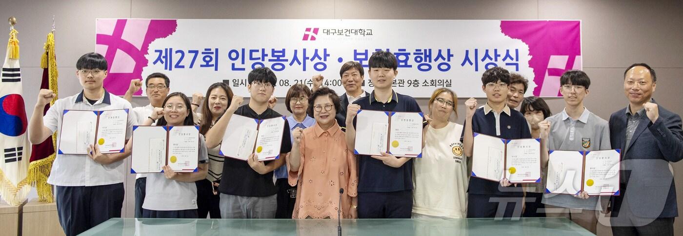 본문 이미지 - 남성희 대구보건대 총장(가운데)이 '제27회 인당봉사상·보현효행상' 시상식에서 수상자과 기념촬영을 하고 있다. (대구보건대 제공)