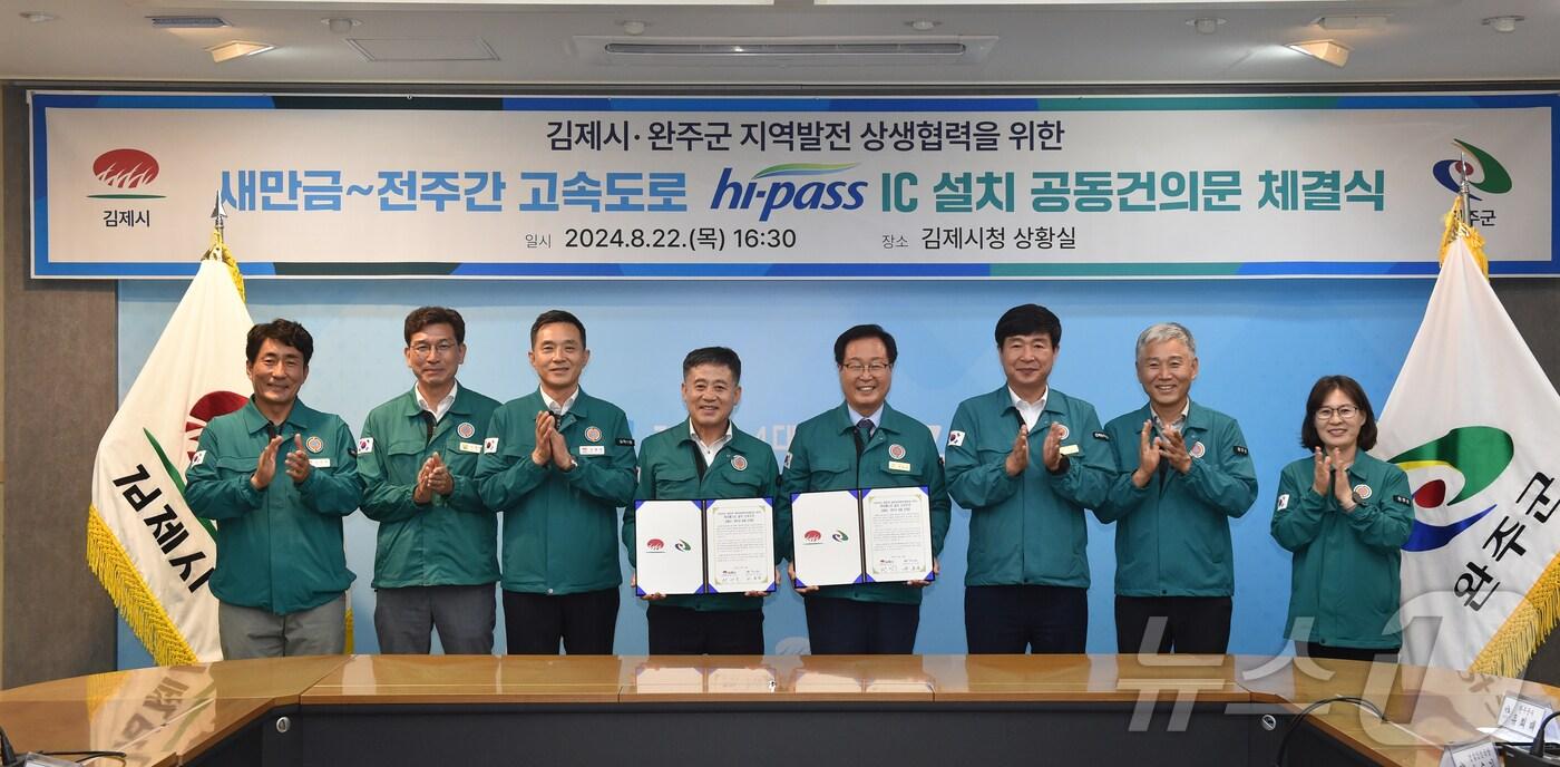 본문 이미지 - 정성주 김제시장(사진 왼쪽에서 네번째)과 유희태 완주군수(다섯번째)가 22일 김제시청 상황실에서 새만금~전주 간 고속도로 하이패스 IC 설치 사업을 촉구하는 공동건의문을 발표하고 있다.(김제시 제공) 2024.8.22/뉴스1