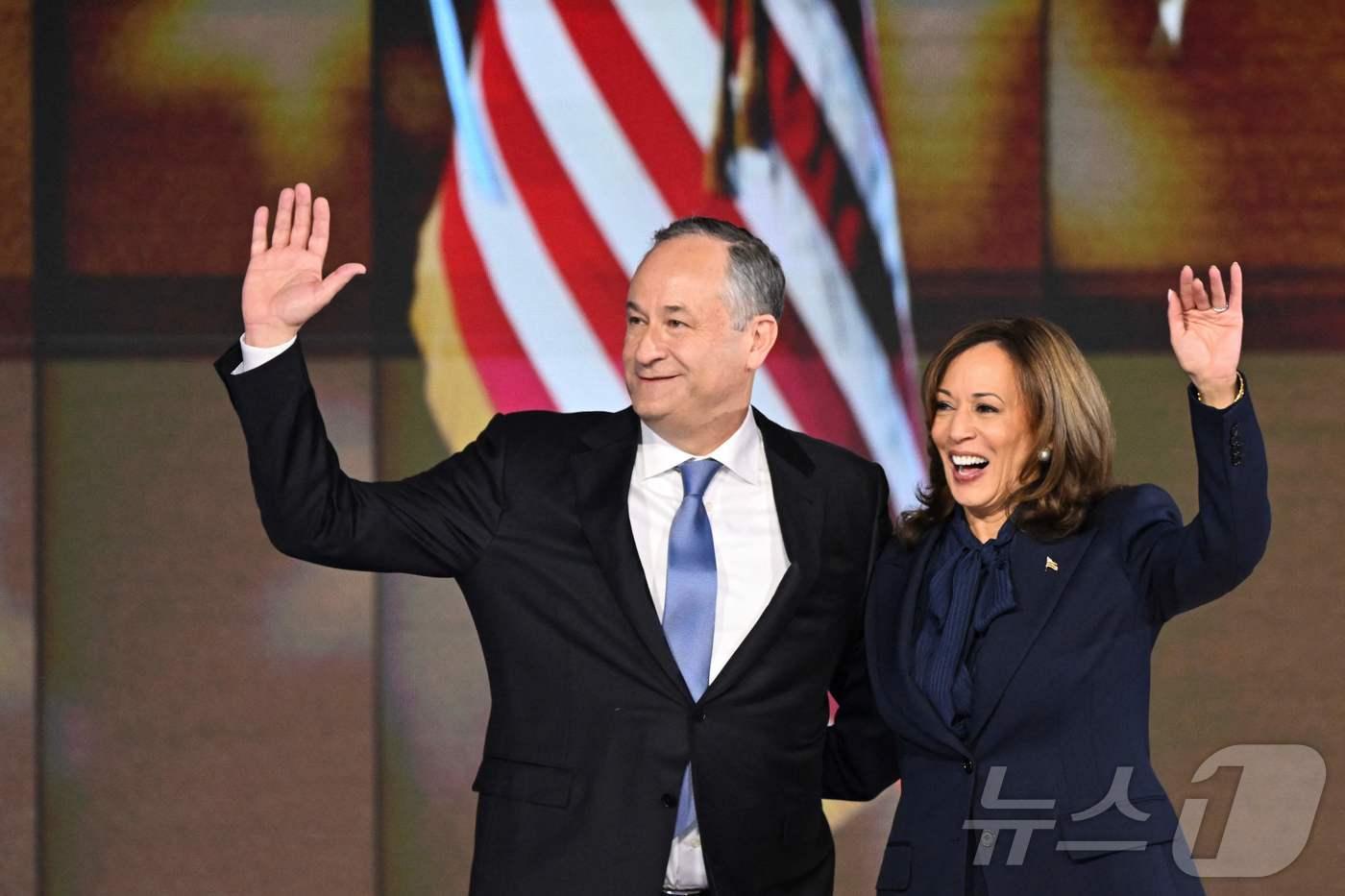 카멀라 해리스 미국 부통령이 22일 (현지시간) 일리노이주 시카고의 유나이티드 센터에서 열린 민주당 전당대회 마지막 날 대선 후보 수락 연설을 마친 뒤 남편 더그 엠호프와 손을 들고 있다. 2024.08.23 ⓒ AFP=뉴스1 ⓒ News1 우동명 기자