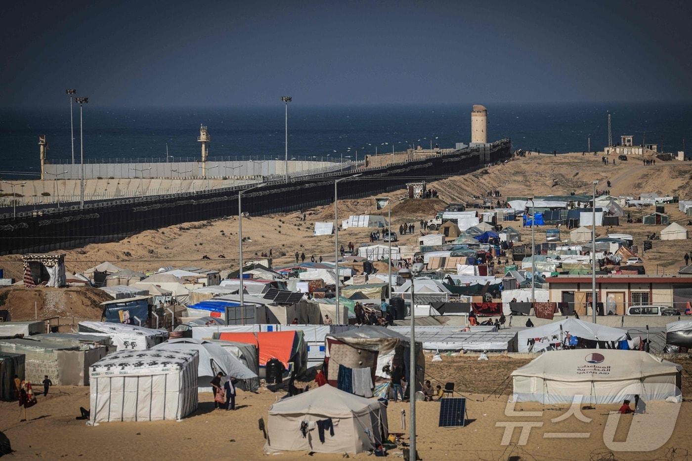 본문 이미지 - 가자지구 남부 라파의 서쪽, 이집트와 국경을 맞대고 있는 필라델피 회랑에 팔레스타인 난민들이 모여들고 있다. 2024.01.14/ ⓒ AFP=뉴스1 ⓒ News1 권진영 기자