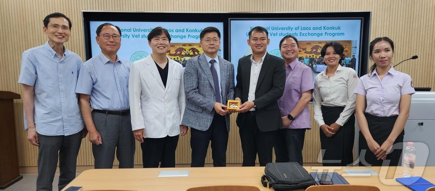 본문 이미지 - 27일 열린 건국대학교와 라오스 국립대학의 수의학 교류를 위한 국제 심포지엄에서 술라삭 라오스 국립대 교수가 기념품을 증정하고 기념 사진을 찍고 있다. 왼쪽부터 정순욱 전임 수의과학연구소장, 최인수 건국대 수의과대학 전임 학장, 윤헌영 건국대 동물병원 원장, 최양규 건국대 수의대 학장, 술라삭 라오스 국립대 수의학과 교수, 박용승 파싸이 동물병원 원장, 칸캄 라오스 국립대 수의학과생, 팔리사 라오스 국립대 수의학과생 ⓒ 뉴스1 한송아 기자
