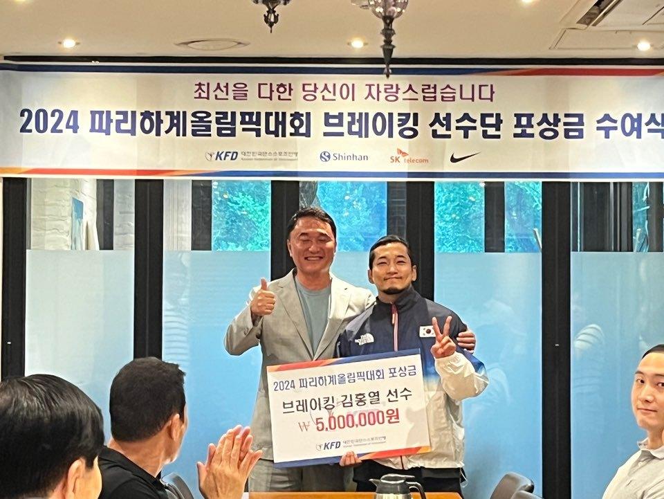 본문 이미지 - 2024 파리 올림픽에 출전한 김홍열(오른쪽)이 대한민국댄스스포츠연맹으로부터 격려금을 받았다. (대한민국댄스스포츠연맹 제공)