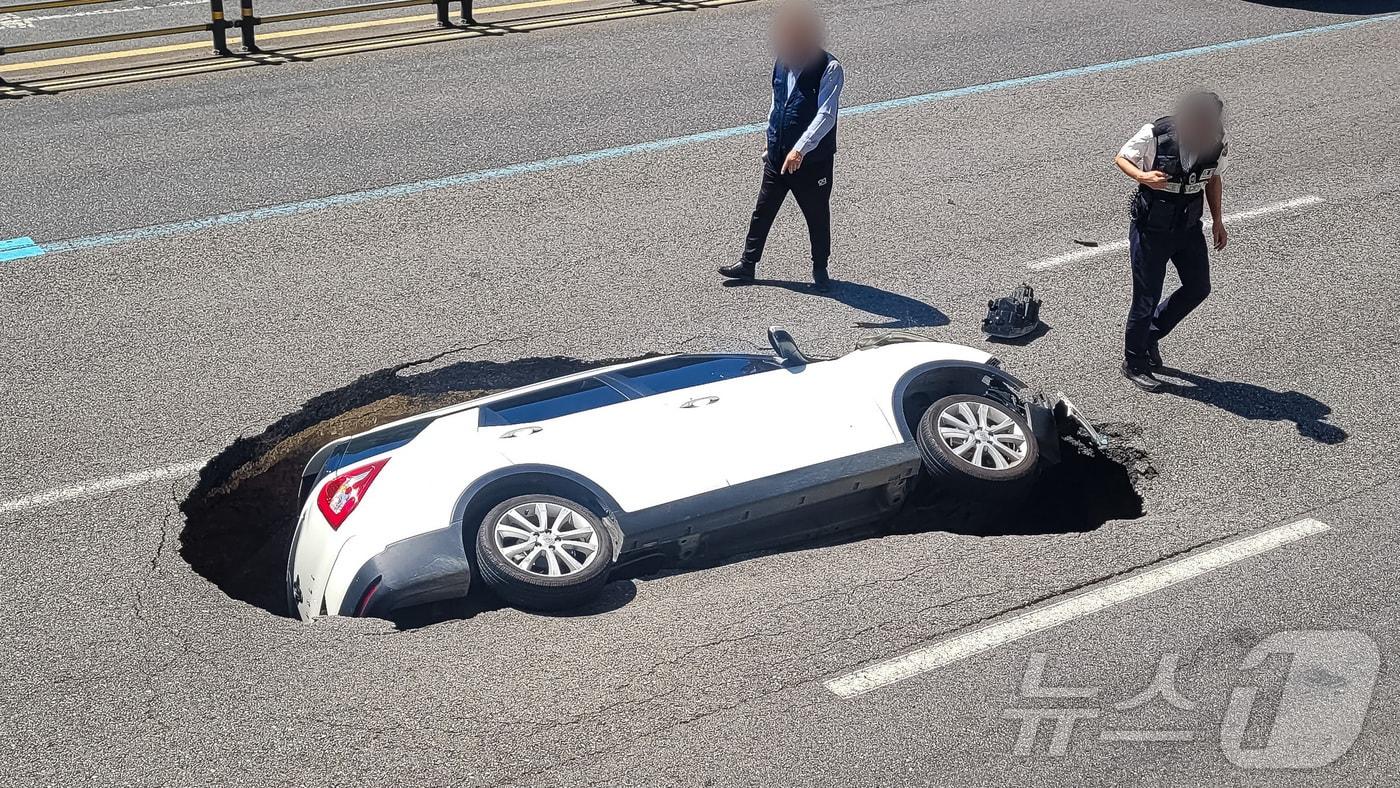 29일 서울 서대문구 연희동의 한 차도에서 땅꺼짐 현상(싱크홀)이 발생해 승용차가 빠져 있다. 소방당국 등에 따르면 이번 사고로 승용차에 탑승 중이던 여성 A 씨(76)가 심폐소생술(CPR)을 받으며 병원으로 옮겨졌다. 운전자인 남성(82) 또한 크게 다쳐 병원으로 이송됐다. (온라인커뮤니티) 2024.8.29/뉴스1