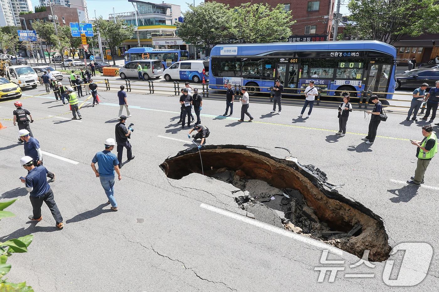본문 이미지 - 29일 서울 서대문구 연희동의 한 차도에서 땅꺼짐 현상(싱크홀)이 발생해 경찰 과학수사대 대원들이 현장을 감식하고 있다. 소방당국 등에 따르면 이번 사고로 승용차에 탑승 중이던 70대 여성과 80대 남성이 중상을 입고 병원으로 옮겨졌다. 2024.8.29 ⓒ 뉴스1 민경석 기자