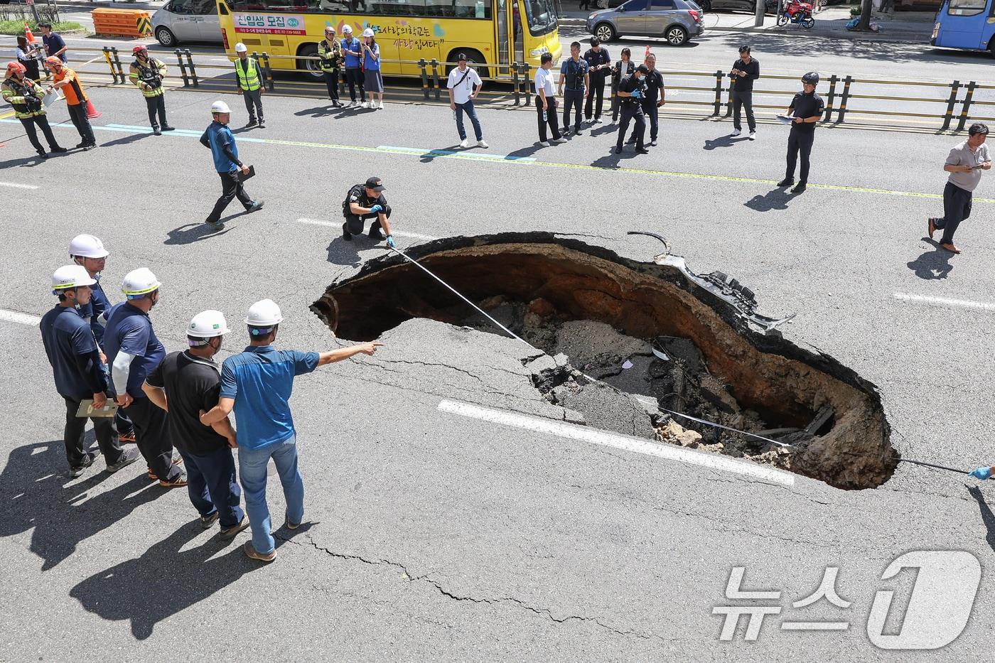 본문 이미지 - 29일 서울 서대문구 성산대교 방면 성산로에서 땅꺼짐 현상(싱크홀)이 발생해 경찰 과학수사대 대원들이 현장감식을 실시하고 있다. 소방당국 등에 따르면 이번 사고로 승용차에 탑승 중이던 70대 여성과 80대 남성이 중상을 입고 병원으로 옮겨졌다. 2024.8.29/뉴스1 ⓒ News1 민경석 기자