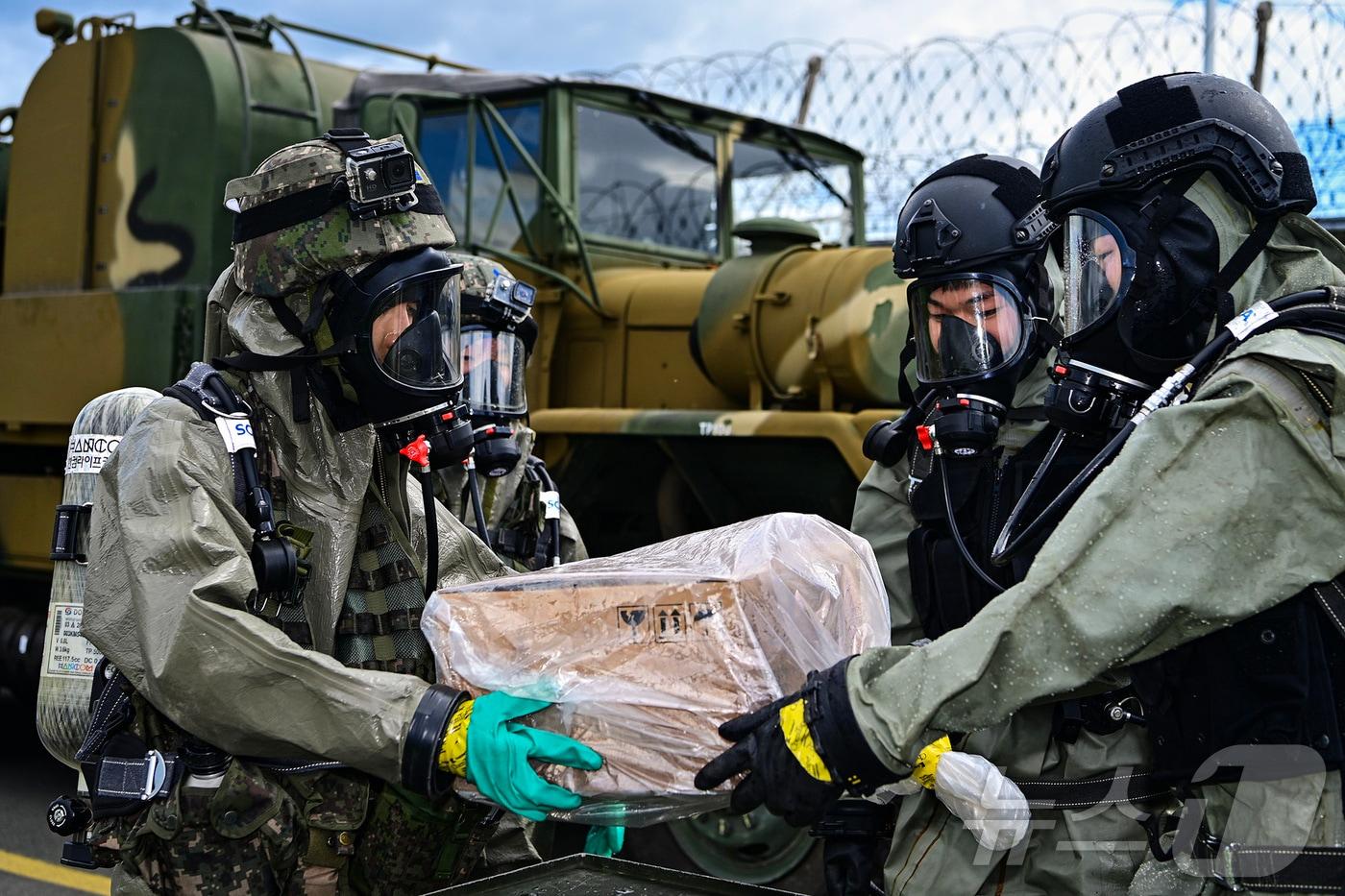 29일 공·육 합동 화생방 훈련에서 공군 제3훈련비행단 화생방신속대응팀이 육군 39사단 대화생방테러특수임무대에게 오염물질을 인계하고 있다.(제3훈비 제공)