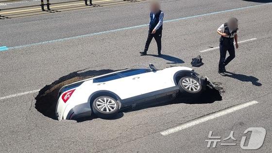 본문 이미지 - 29일 서울 서대문구 연희동의 한 차도에서 땅 꺼짐 현상(싱크홀)이 발생해 승용차가 빠져 있다. (온라인 커뮤니티) 2024.8.29/뉴스1
